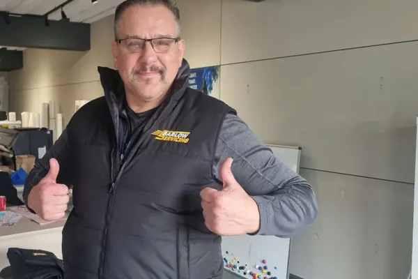 John Barlow, CEO of J Barlow Servicing, giving a thumbs up in his embroidered bodywarmer